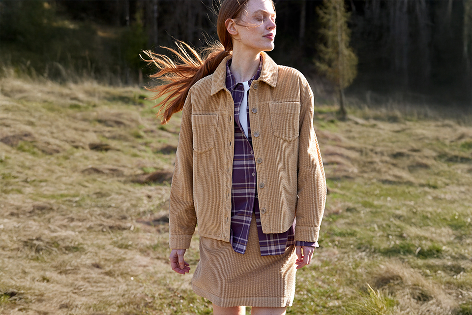 Frau trägt lässige Outdoor-Kleidung in natürlicher Umgebung