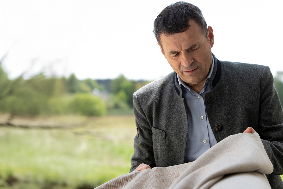 Mann hält Stoff in den Händen