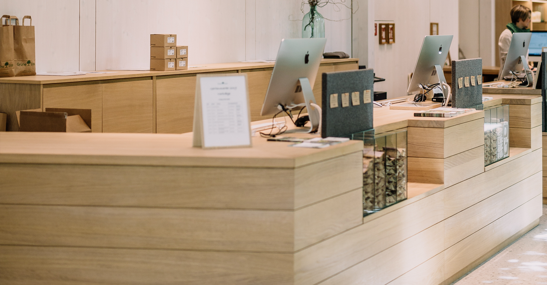 Rosa Blumen und im Hintergrund eine grüne Wiese und die Glasfassade der Grüne Erde-Welt