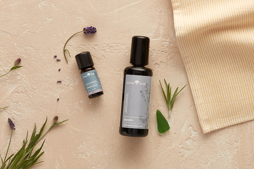 Basisöl und Aromaöl mit dekorativen Pflanzen auf hellem Untergrund