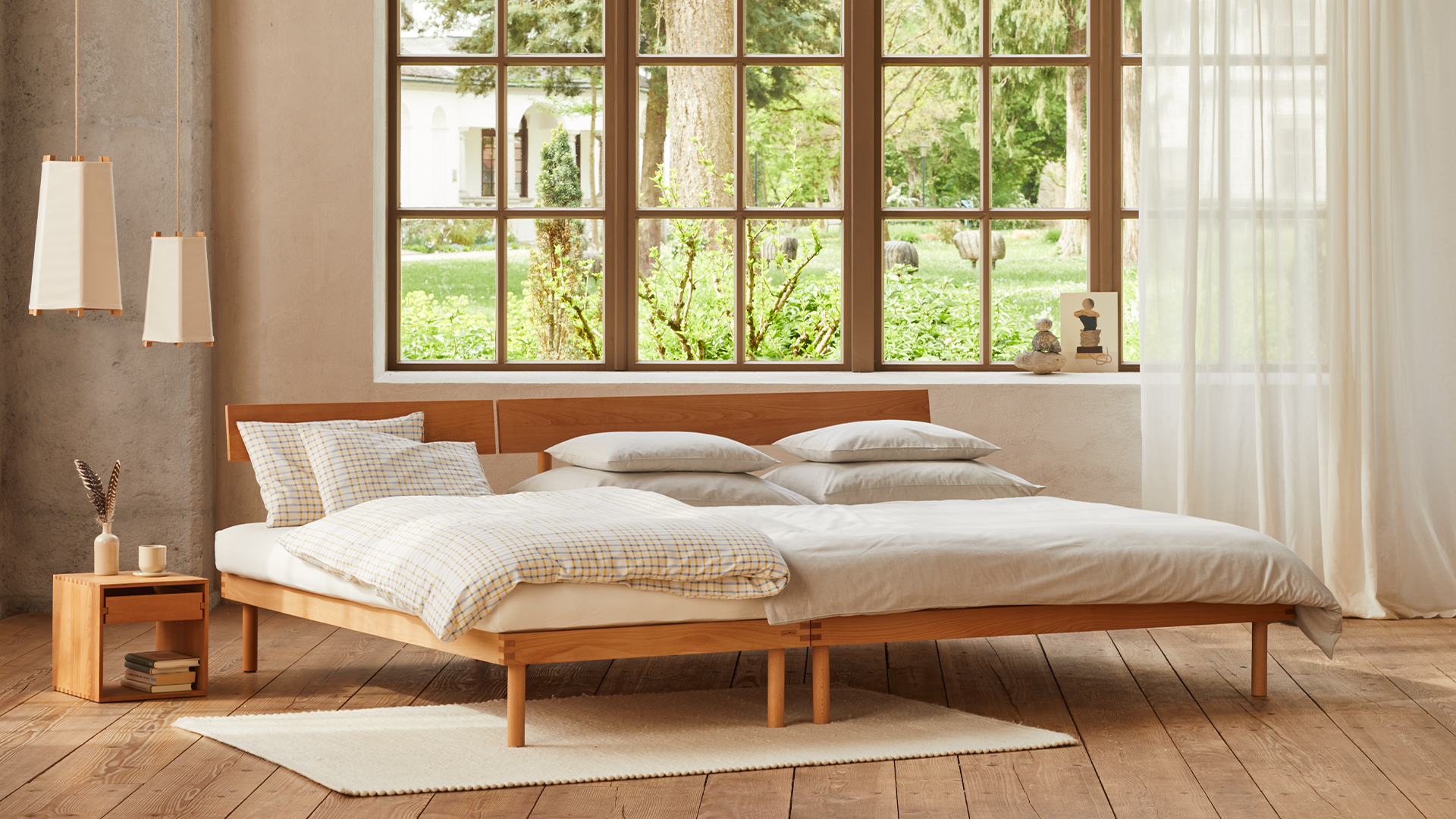 Familienbett Jukai Pur steht vor einem großen Fenster