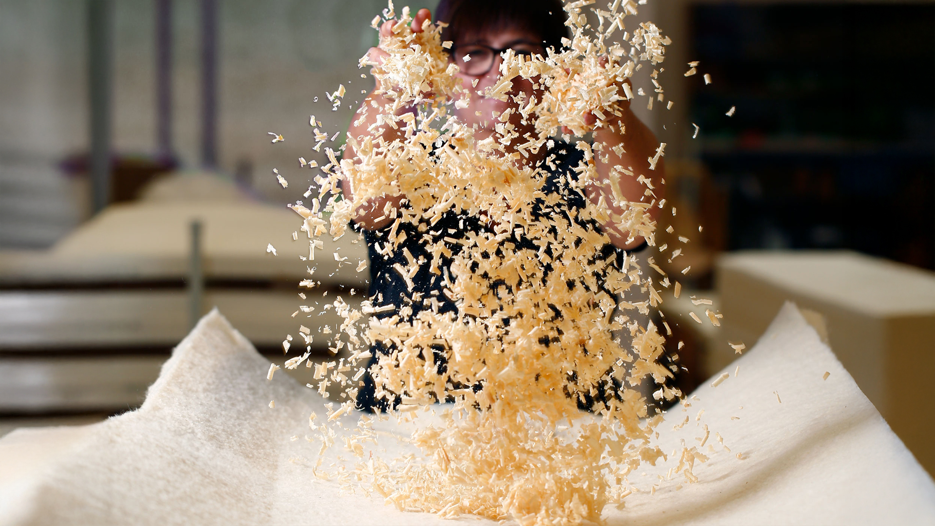 Eine Frau wirft Zirbenspäne in die Luft