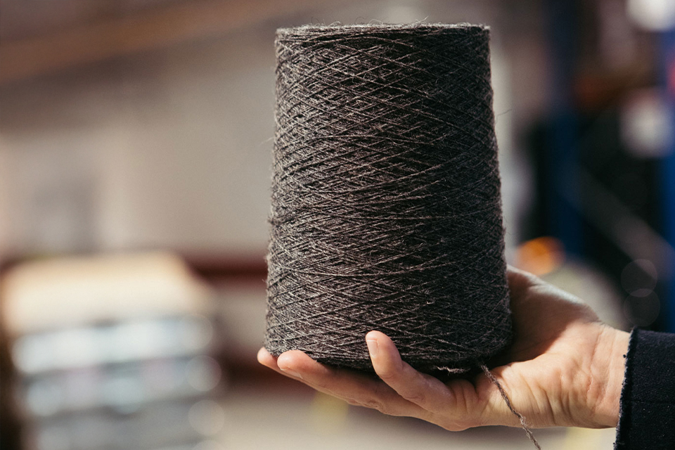 Hand hält Rolle aus Stoff