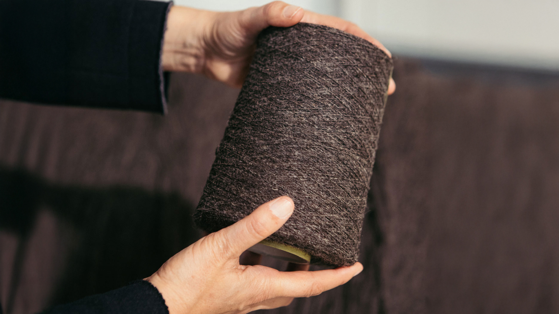 Frau hält eine dunkle Stoffrolle in den Händen