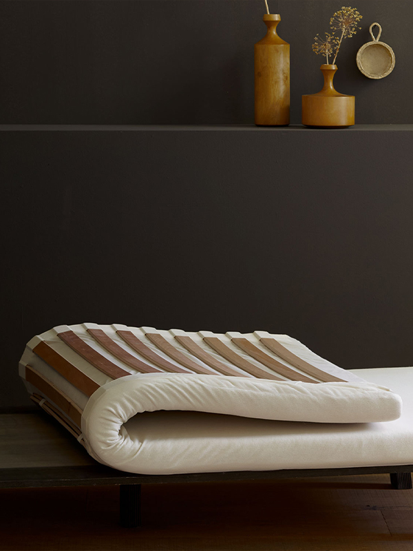 Elastisches Federelement auf einem Holzgestell vor einer dunklen Wand