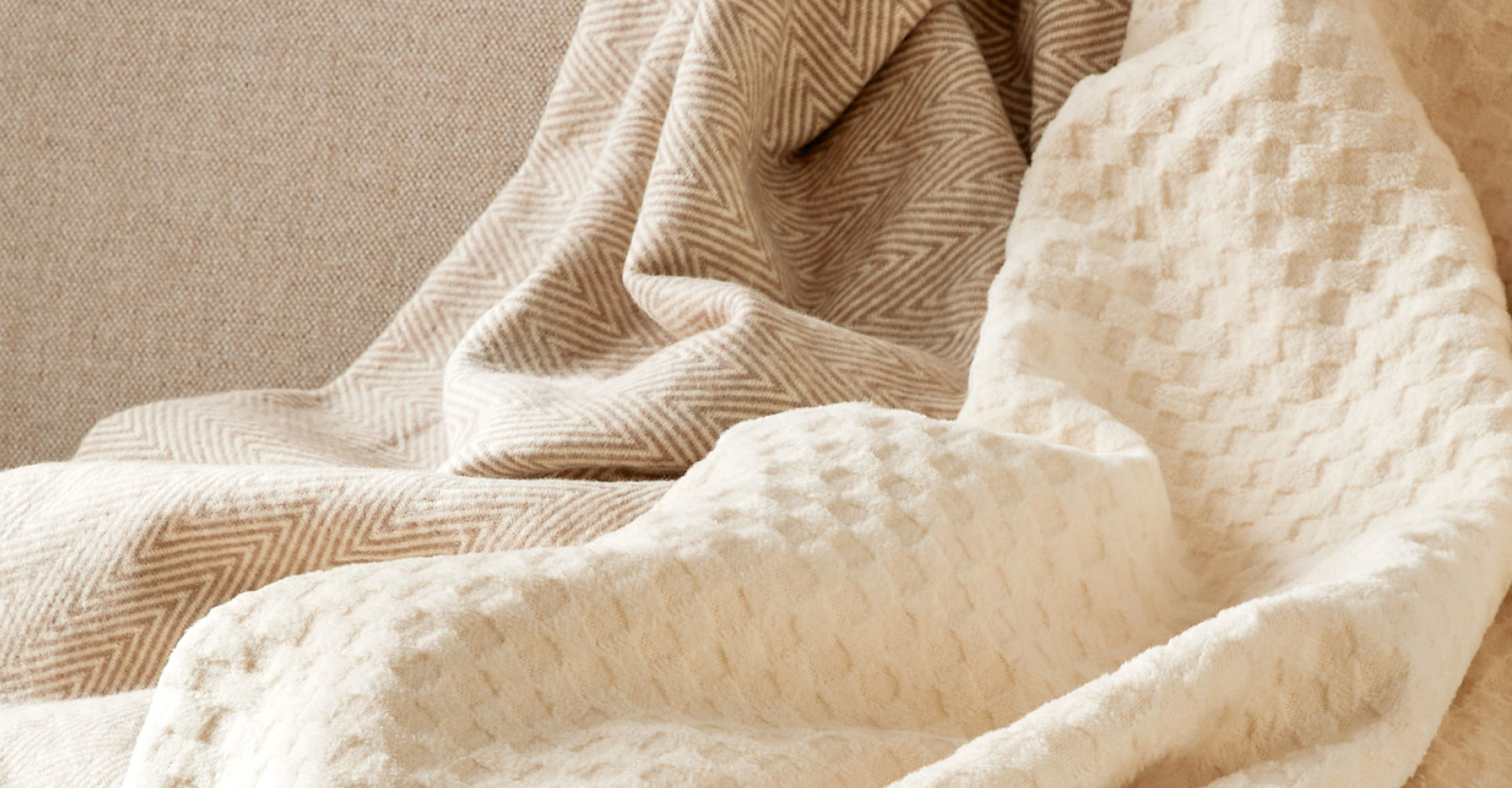 Beige und weiße Wohndecke auf Sofa liegend