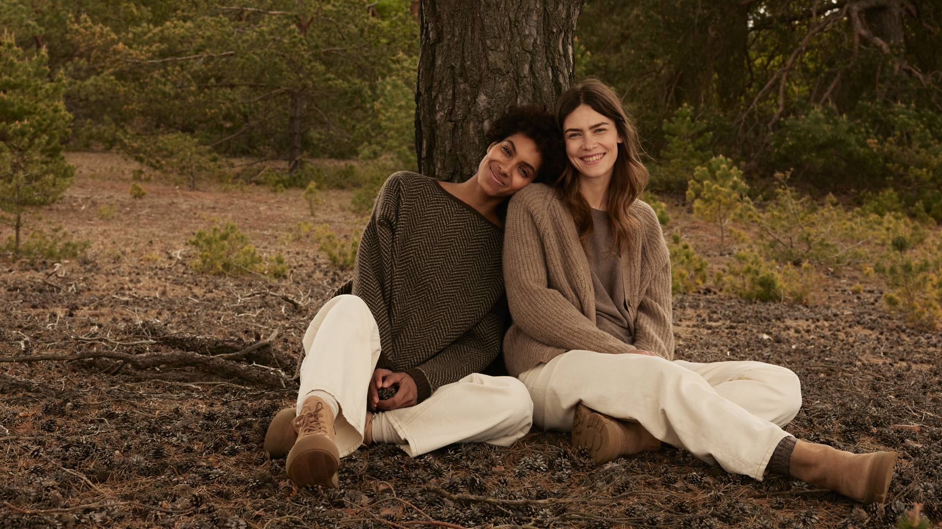 Zwei Personen sitzen entspannt auf einer Decke im Freien