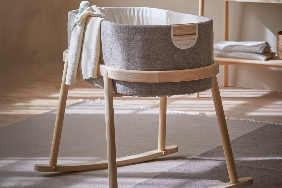 Babywiege Serafin mit Stillkissen und Kuscheldecke im Kinderzimmer