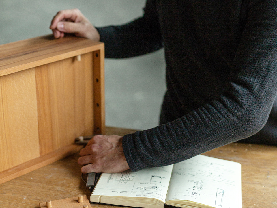 Skizzenbuch und Hände beim zusammenstecken einen Möbelstücks