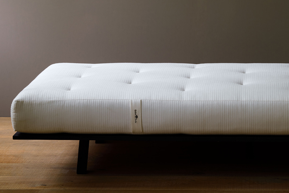 Hochwertige Naturmatratze auf einem dunklen Holzgestell