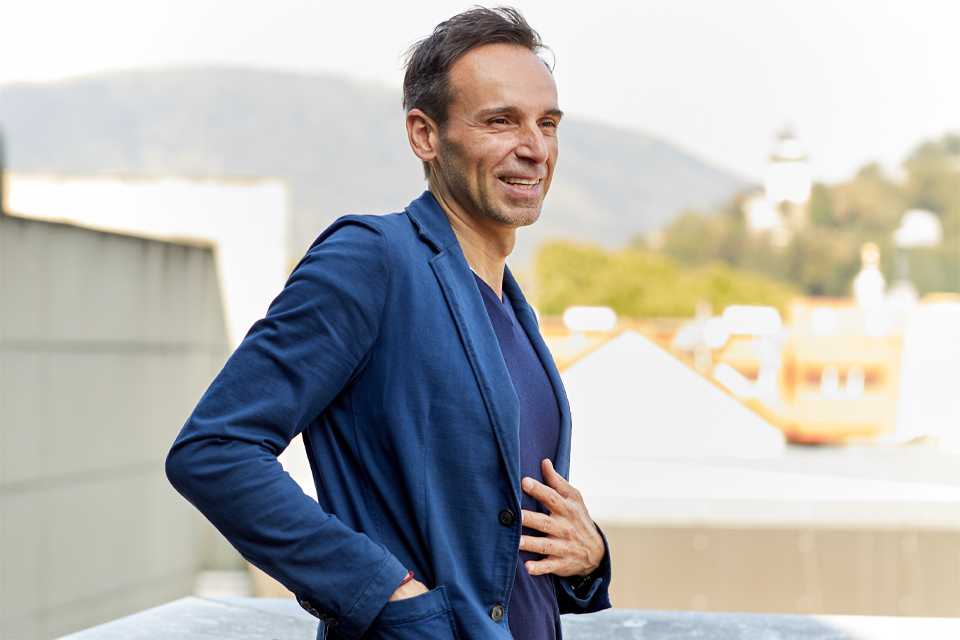 Lächelnder Mann im Freien mit Blick über Dächer und Landschaft