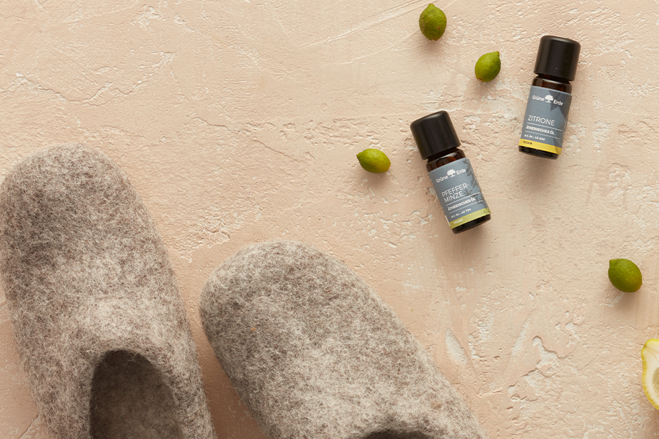 Ätherische Öle mit Knospen und einer Zitrone dekorativ angeordnet