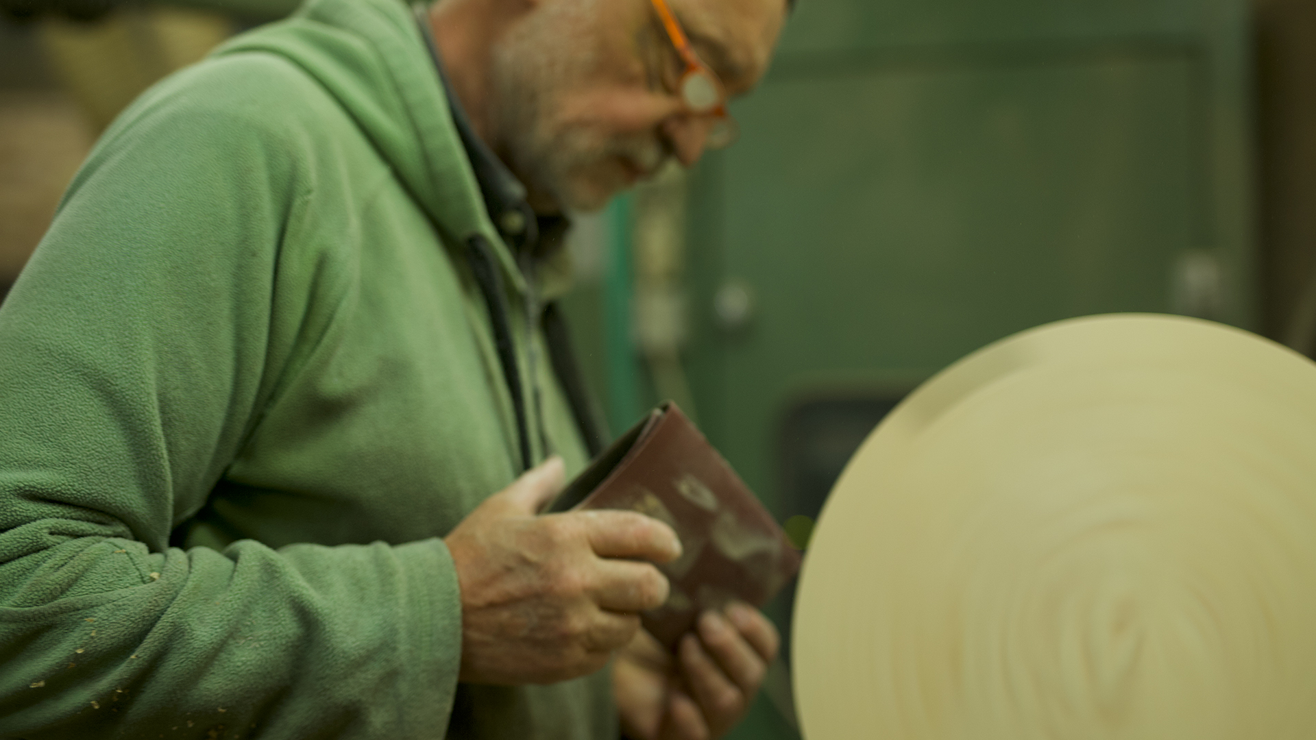 Mann schleift einen Gegenstand aus Holz ab