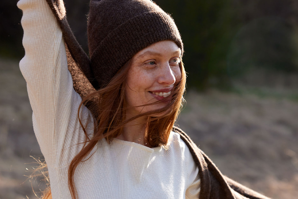 Frau mit Mütze lächelt in herbstlicher Natur