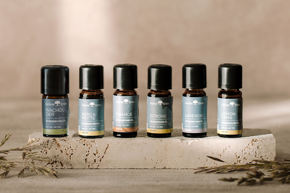 Reihe ätherischer Öle in kleinen Fläschchen auf Naturstein