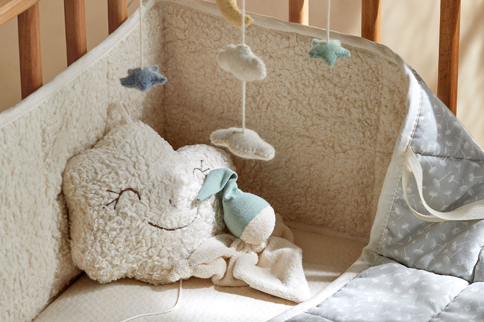 Schlafschlange und Spieluhr Wölchen im Kinderbett liegend