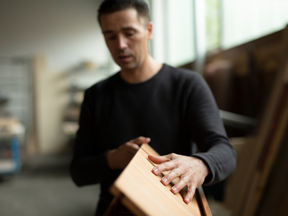 Handwerker oder Designer bei der präzisen Arbeit an einem Möbelstück aus Holz