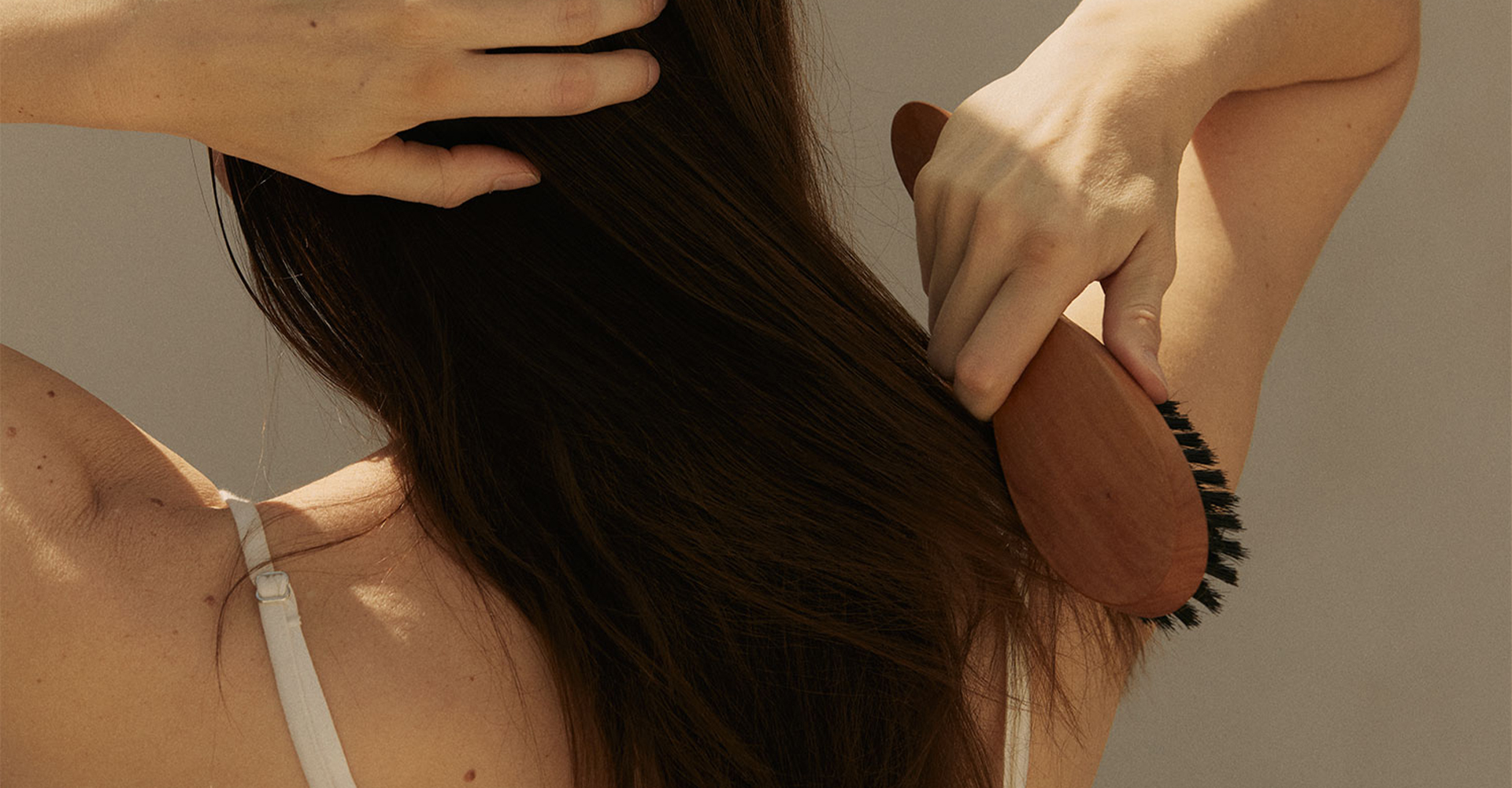 Frau bürstet ihre langen Haare