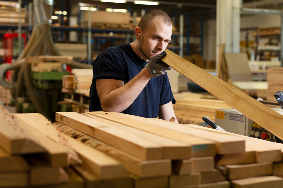 Schreiner bearbeitet Holz in Werkstatt nachhaltige Möbelproduktion