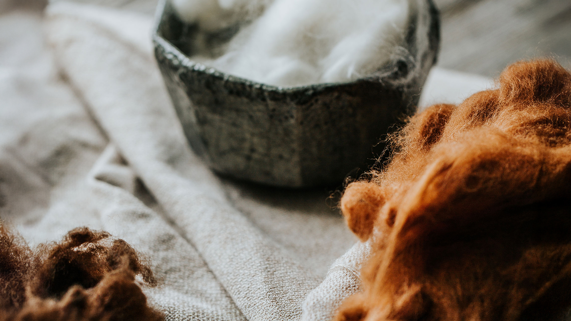 Verschiedene Naturmaterialien stehen in Schüsseln auf einem grauen Stofftuch