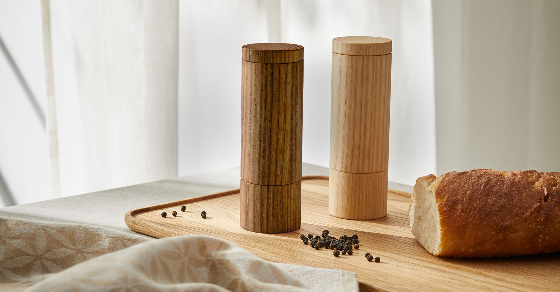 Holz Gewürzmühlen und Brot auf einem Holztablett mit Geschirrtuch