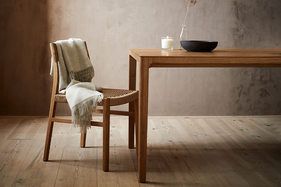 Holztisch mit Stuhl und Decke in einem Raum