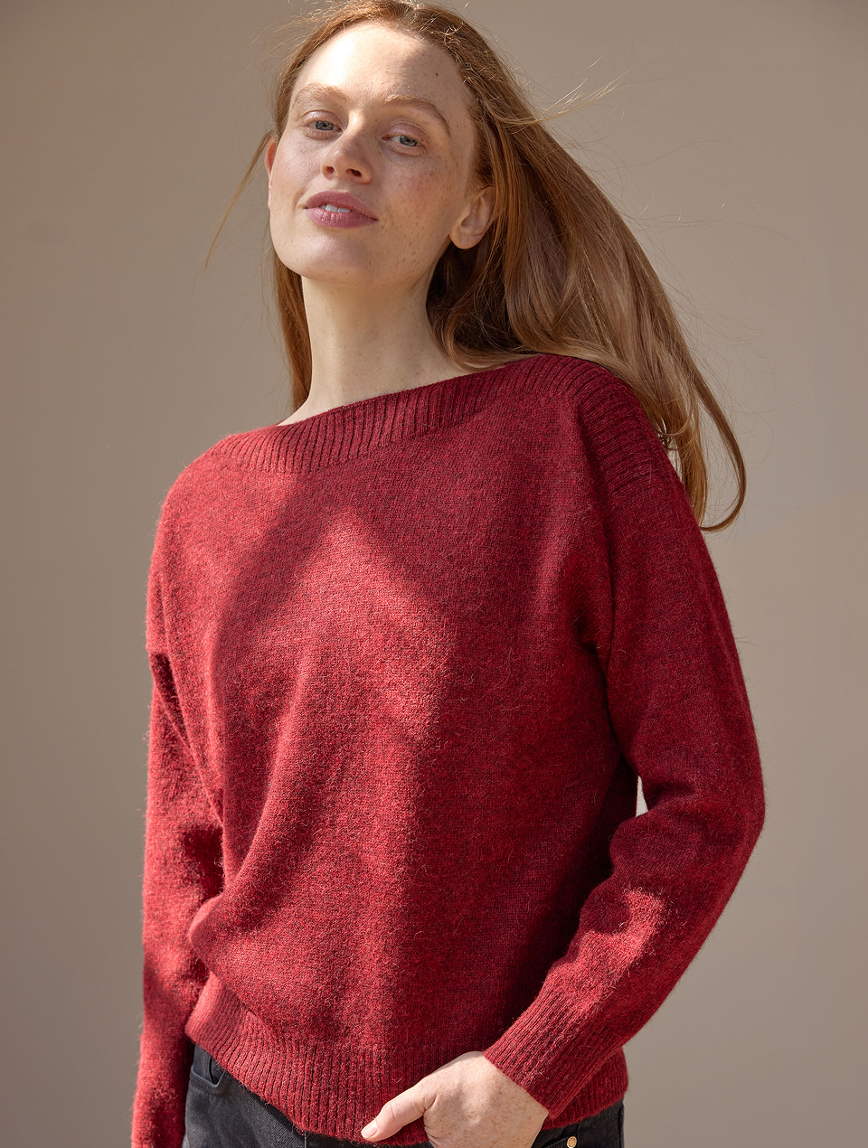 Frau mit rötlichen Haaren trägt einen roten Pullover