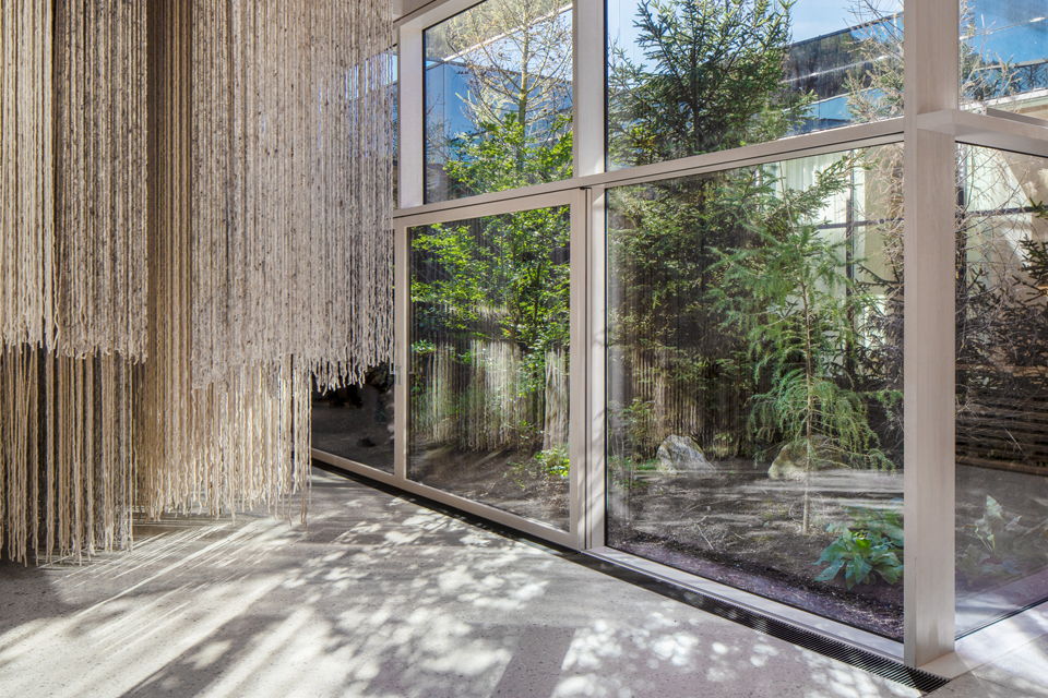 Helle Vorhänge vor großen Fenstern mit Blick ins Grüne