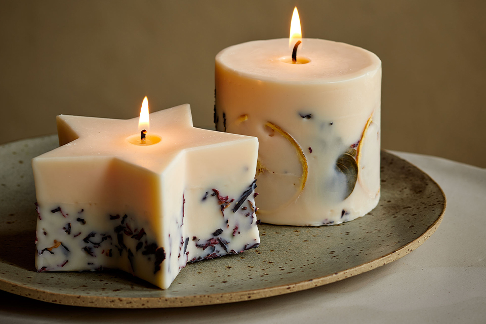 Duftkerzen mit Blüten auf Teller warmes gemütliches Licht Atmosphäre