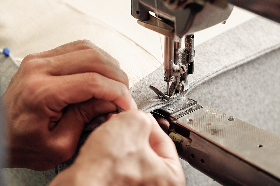 Hände beim nähen des Möbelstoffes