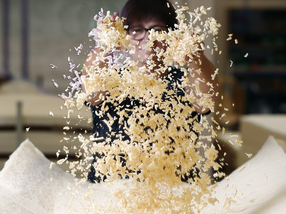 eine Frau wirft Zirbenspäne in die Luft