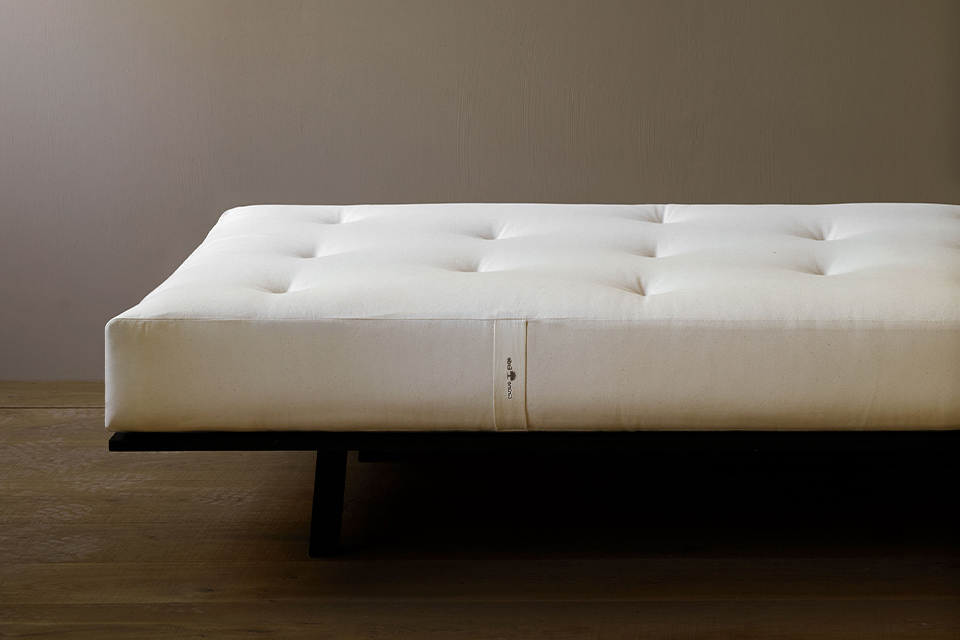 Hochwertige Naturmatratze auf einem dunklen Holzgestell