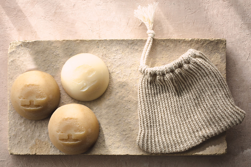 Drei Seifen auf einer Steinplatte neben einem kleinen Säckchen