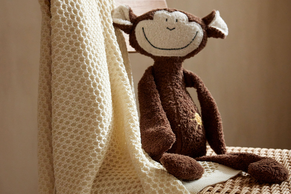 Affe Abu sitzt auf einem Stuhl