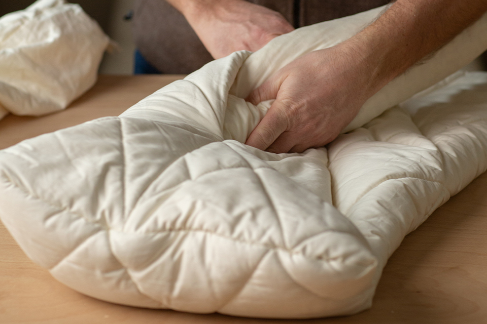 Eine Person befüllt das hochwertige Komfortkissen