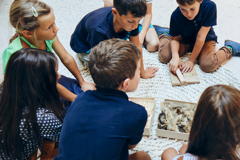 Kinder arbeiten gemeinsam am Boden bei kreativer Gruppenaktivität
