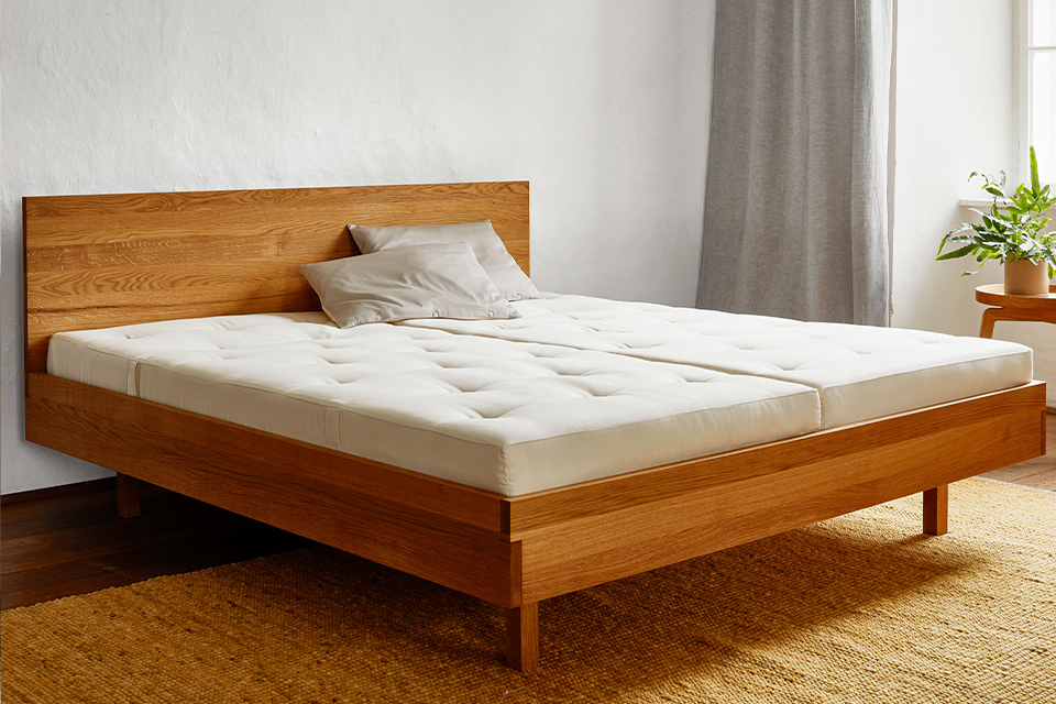 Bett Tesoro mit Naturmatratzen vor einem Fenster