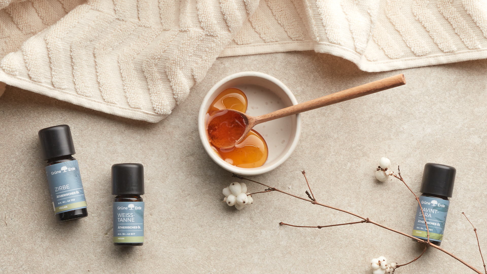 Ätherische Öle neben einer Schale mit Honig