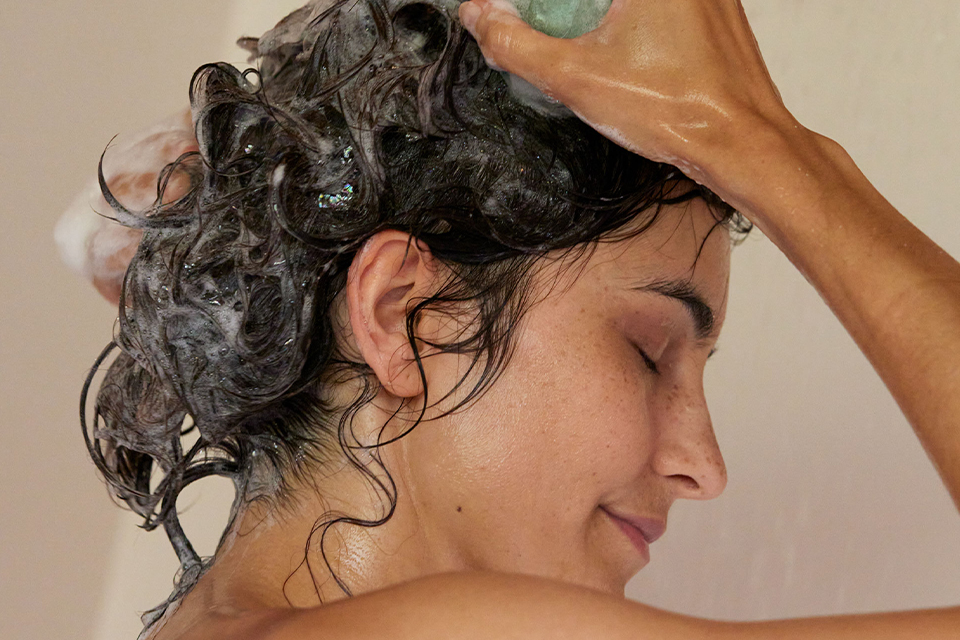 Frau wäscht sich ihre Haare mit einem festen Shampoo