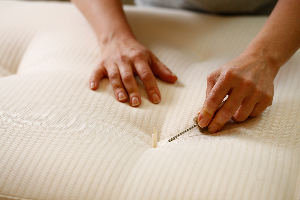 Zwei Hände bei der Herstellung einer hochwertigen Naturmatratze