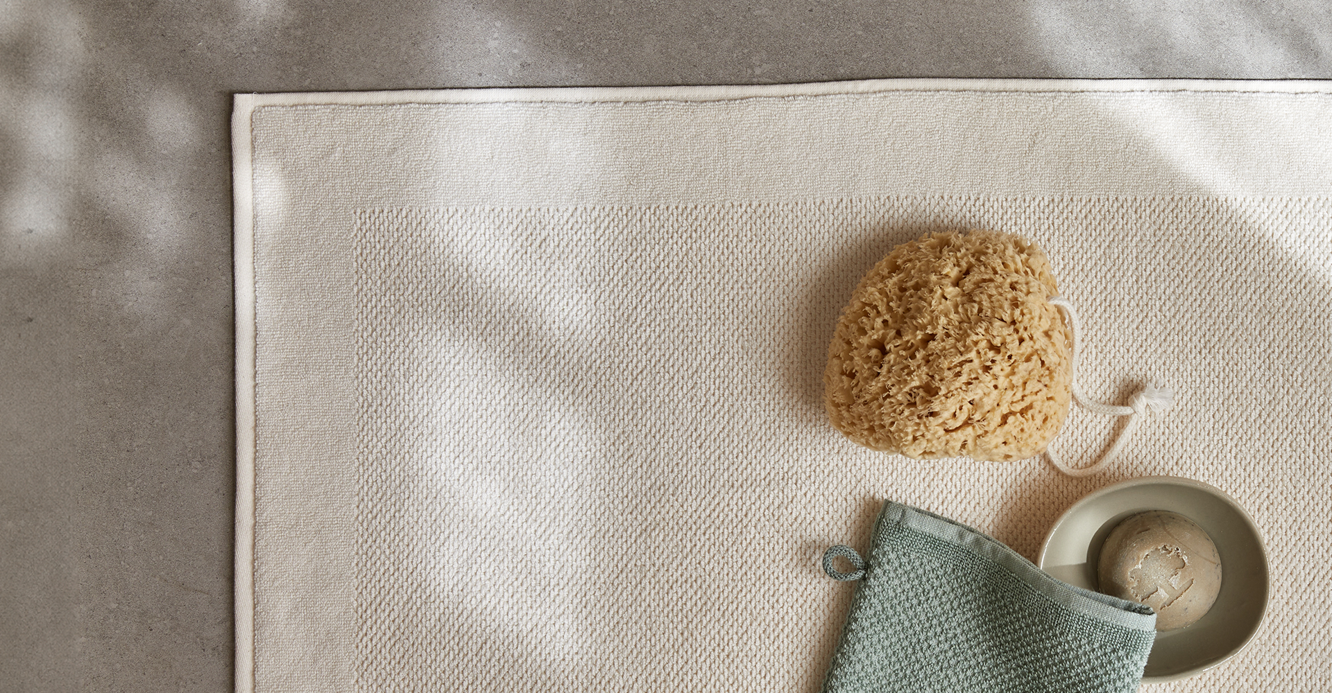Beige Badematte mit Schwamm und Accessoires