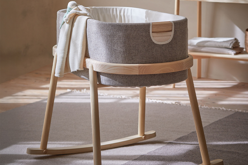 Babywiege Serafin mit Stillkissen und Kuscheldecke im Kinderzimmer