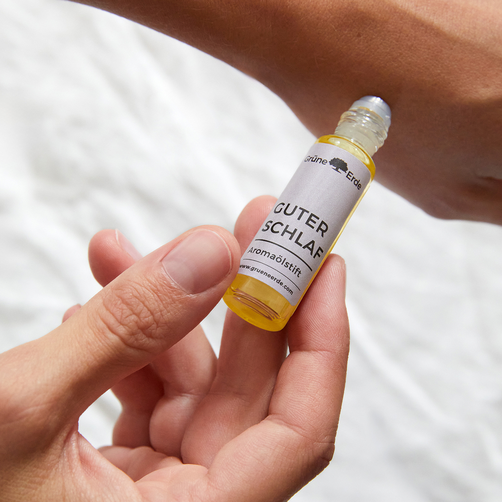 Hand wendet Aromaölstift auf der Haut an