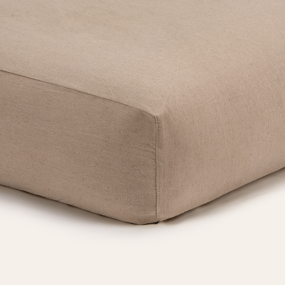 Beiges Spannleintuch auf eine Matratze gespannt