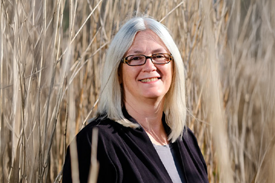 Lächelnde Frau steht im Schilf