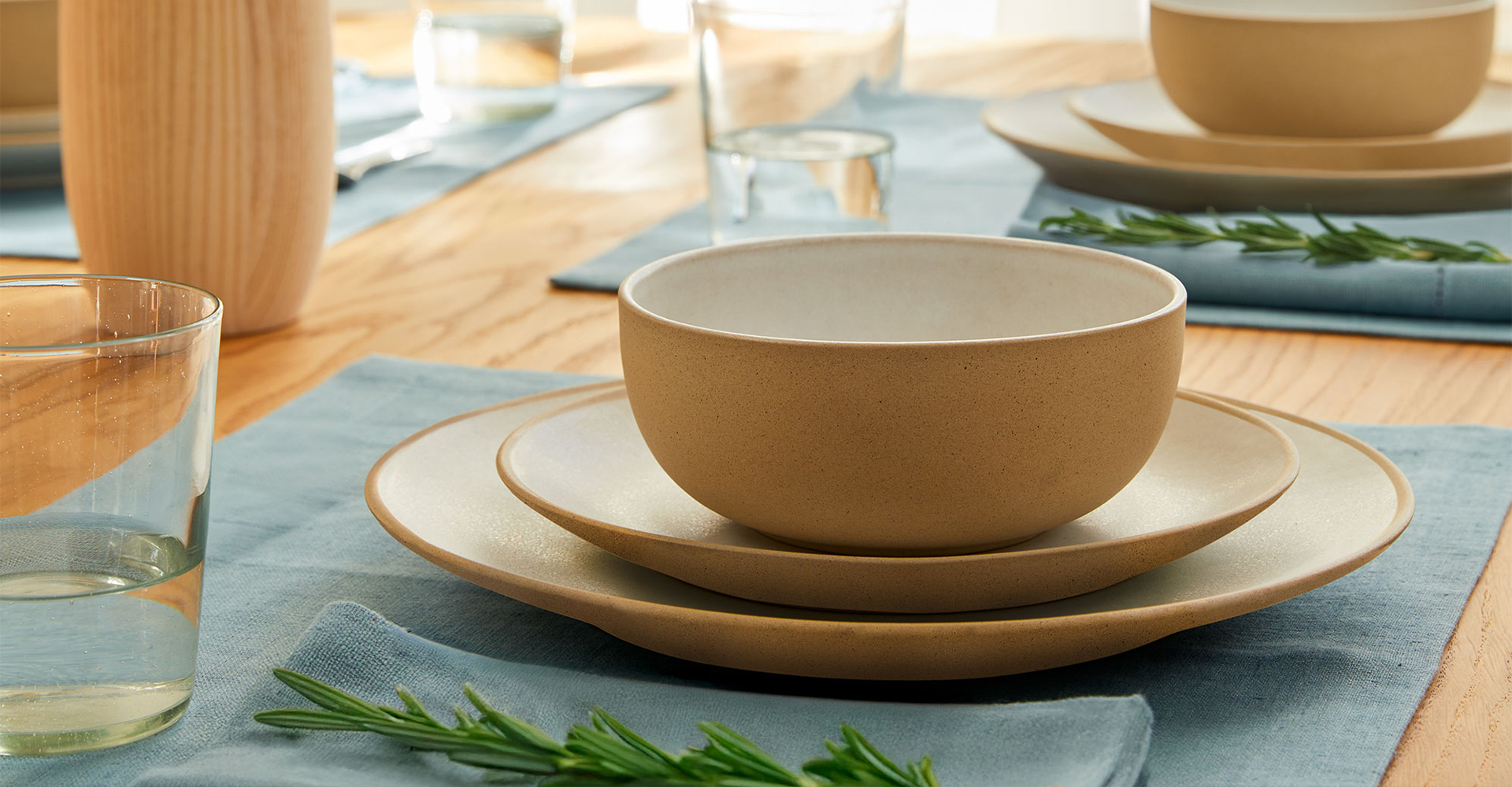 Dekorierter Tisch mit Gläser. Teller, Besteck und Kerzen in der Mitte