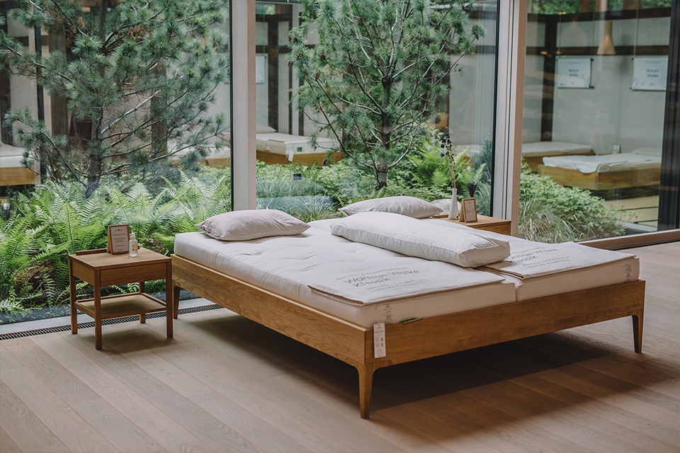 Massivholzbett mit Naturmatratratzen zum Probeliegen in der Grüne Erde Welt