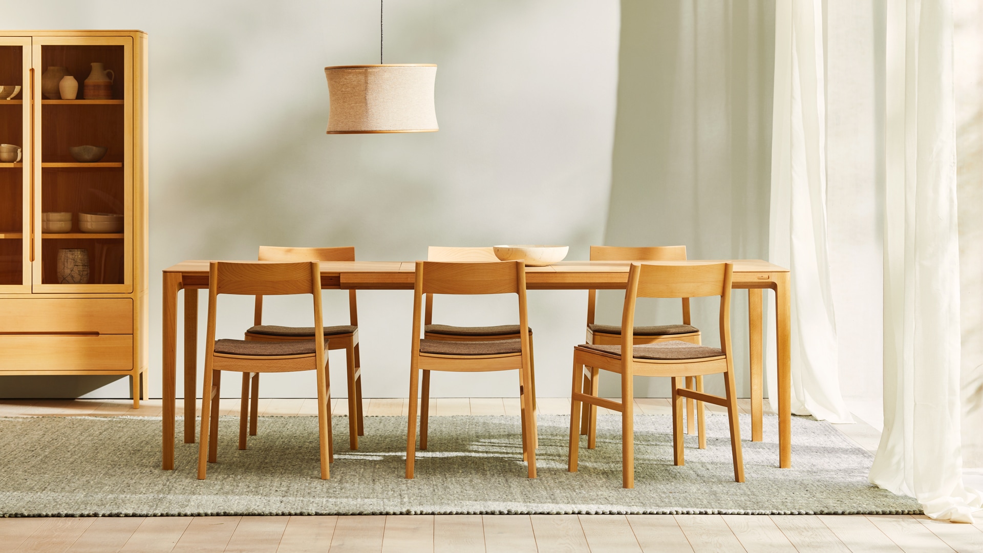 Massivholztisch Tenso mit Stühlen und Vitrine im Esszimmer