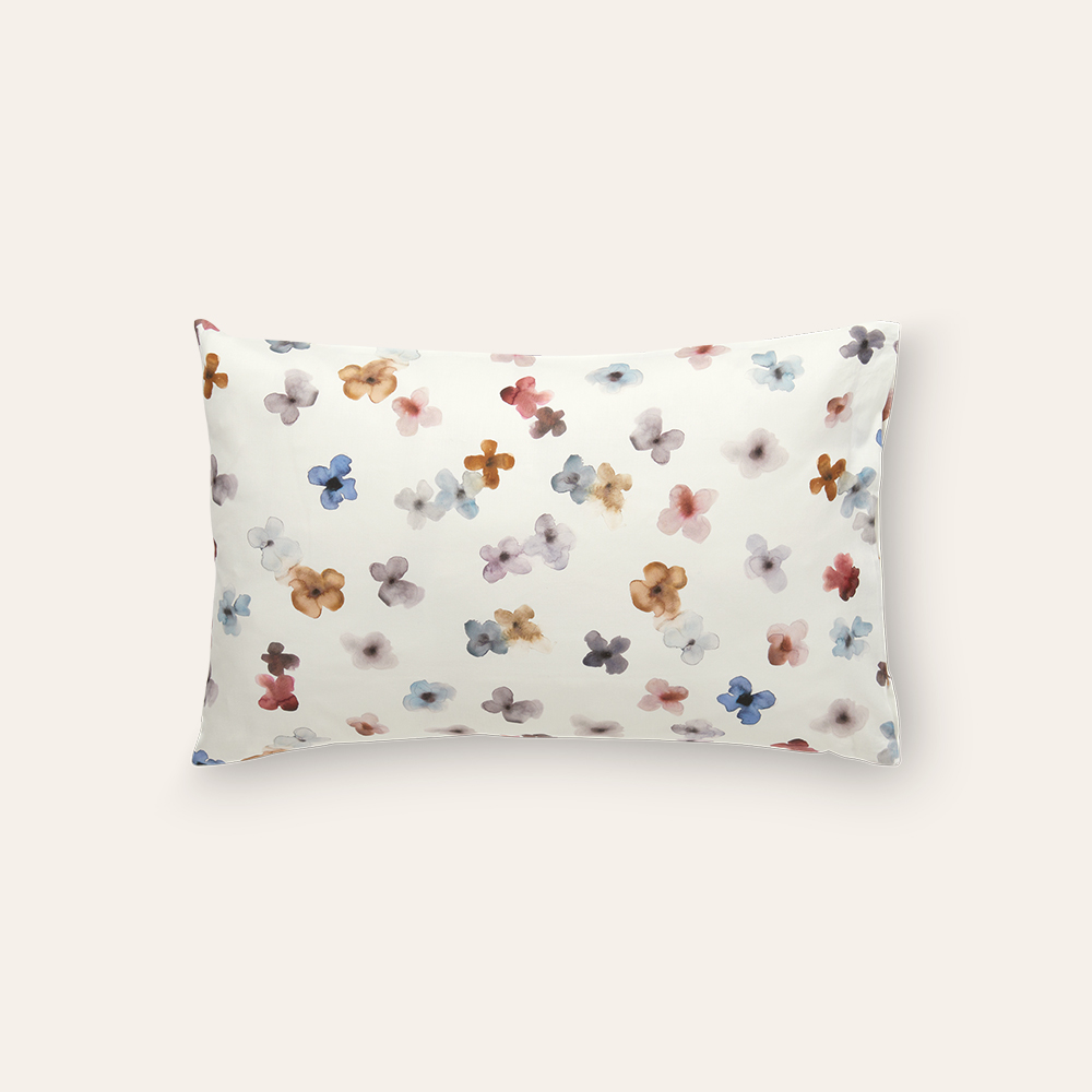 Weißes Kopfkissen mit buntem Blumenmuster auf weißem Hintergrund