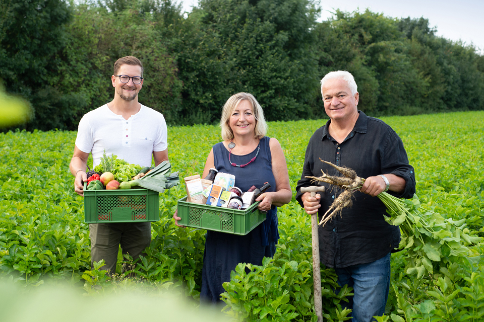Personen halten Körbe mit Gemüse in den Händen